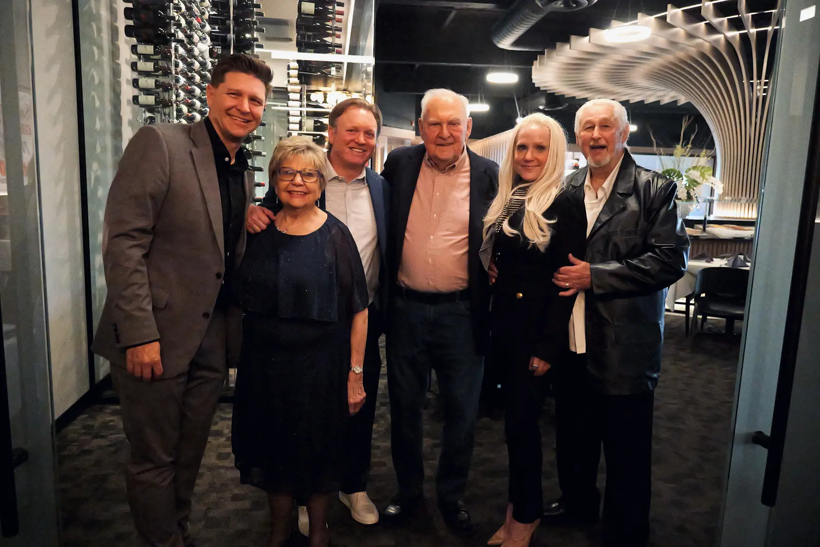 Guests gathered for a photo by the wine wall