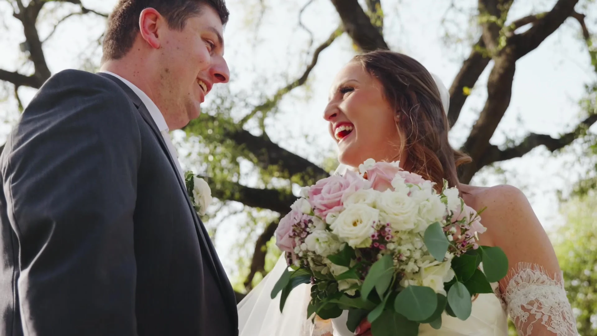 Bride laughing with her groom, holding her bouquet